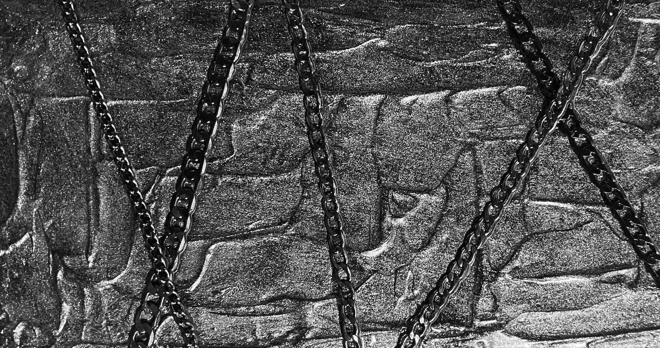 DEETROCASE — chain wrapped across a brushed metal surface
